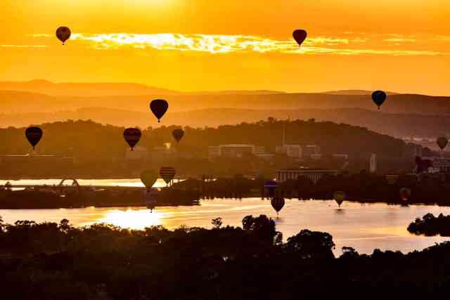 Globos aerostáticos sobre el lago burley griffin en Canberra al amanecer.
